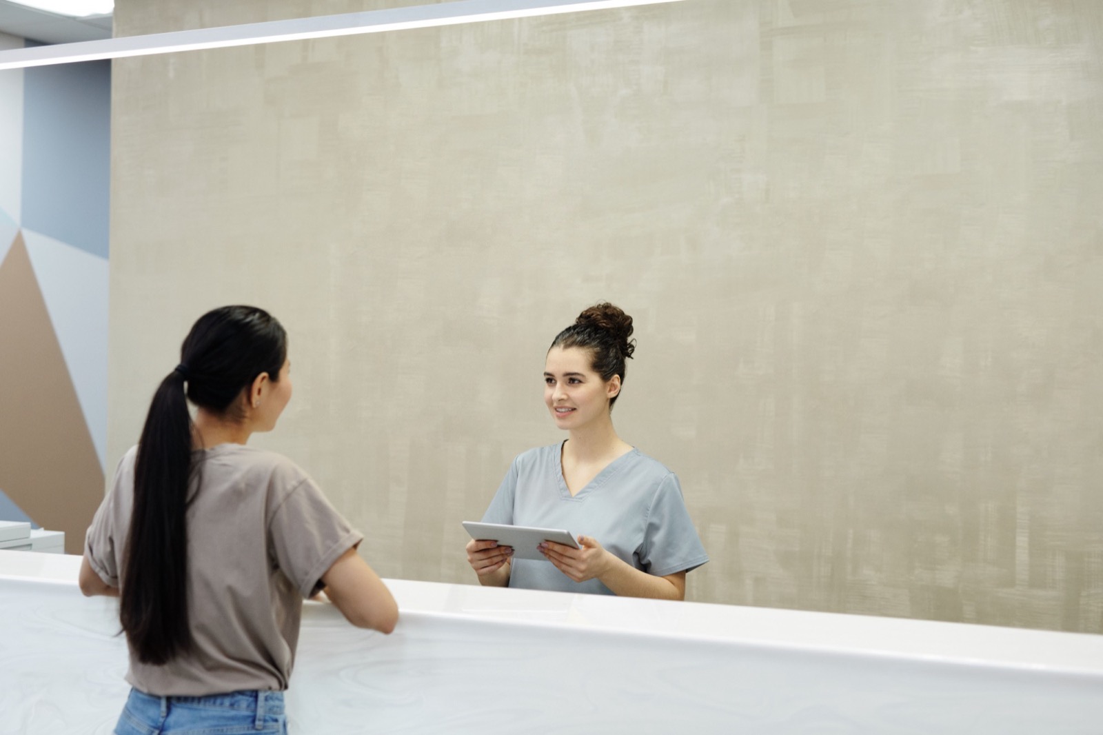 A front desk coordinator welcoming a patient